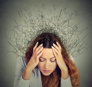 Woman with head in hands dealing with anxiety